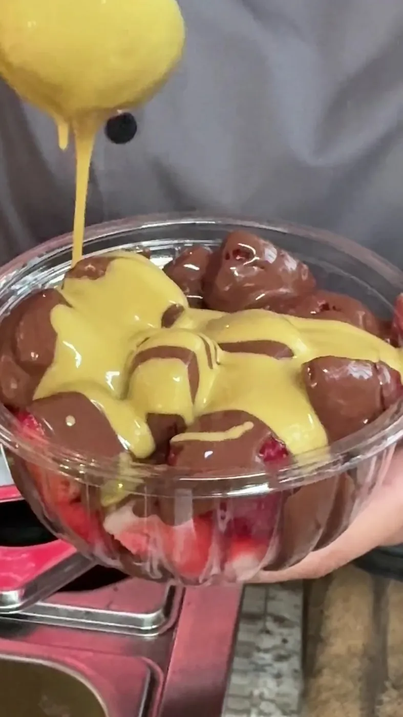 Crema de pistache cayendo sobre Fresas Dubai con chocolate
